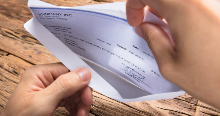 Businessman Opening Envelope With Paycheck